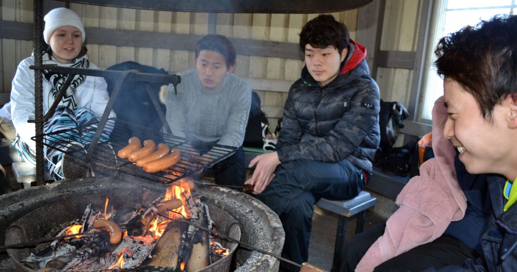 Japanese Students grilling sausages in the hut.