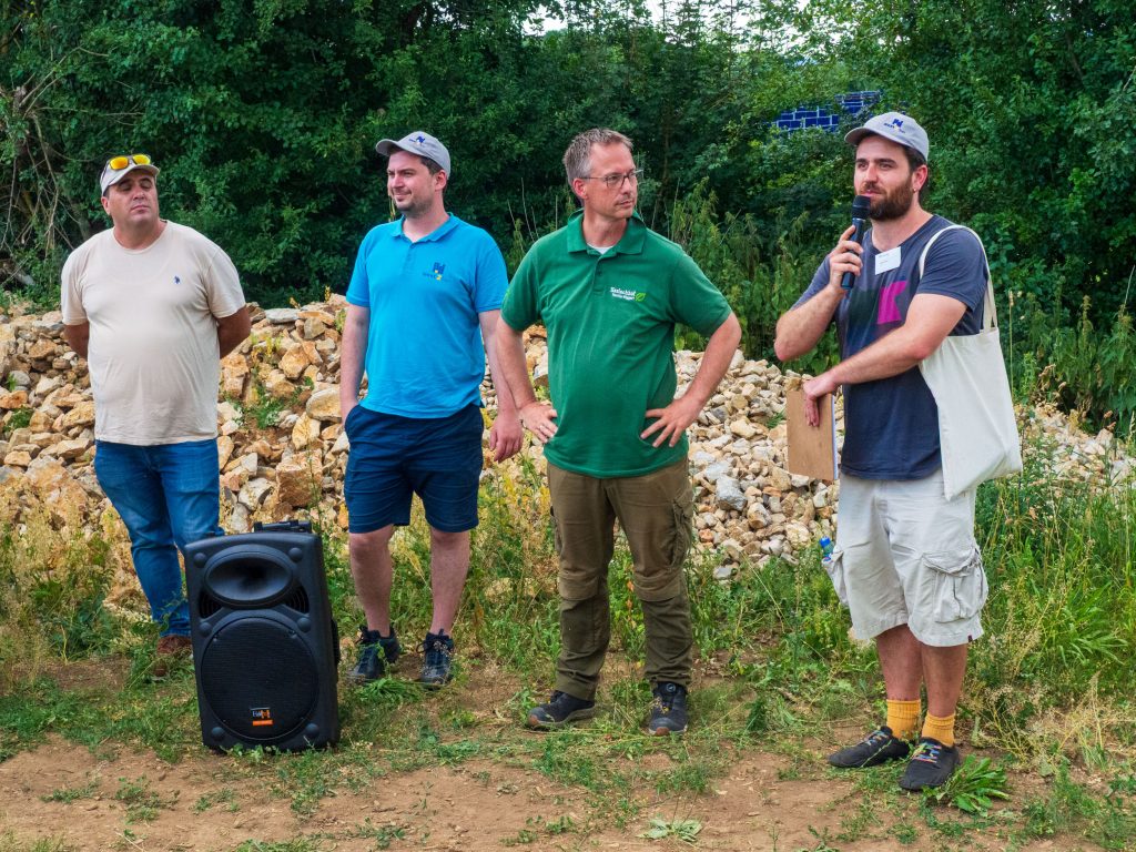 Löffingenin - Haslachhof Familie Wiggertin Agrivoltaics -alueen esittelystä kuva, tilan omistaja Wolfram Wiggert keskellä vihreässä paidassa. Herra Wiggertin vasemmalla puolella edustaja Jerome Linz ja oikealle edustaja Kovac molemmat Next2Sun AG:stä. Kuva Jari Mustonen